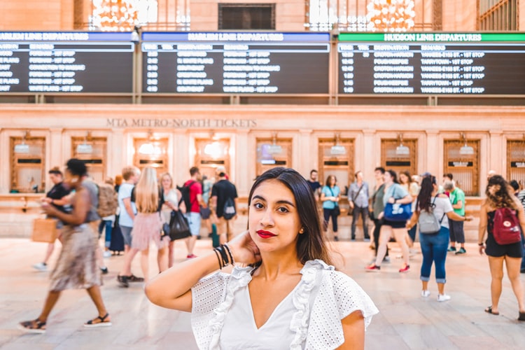  A photo of a beautiful Latina woman in a white top at a train station