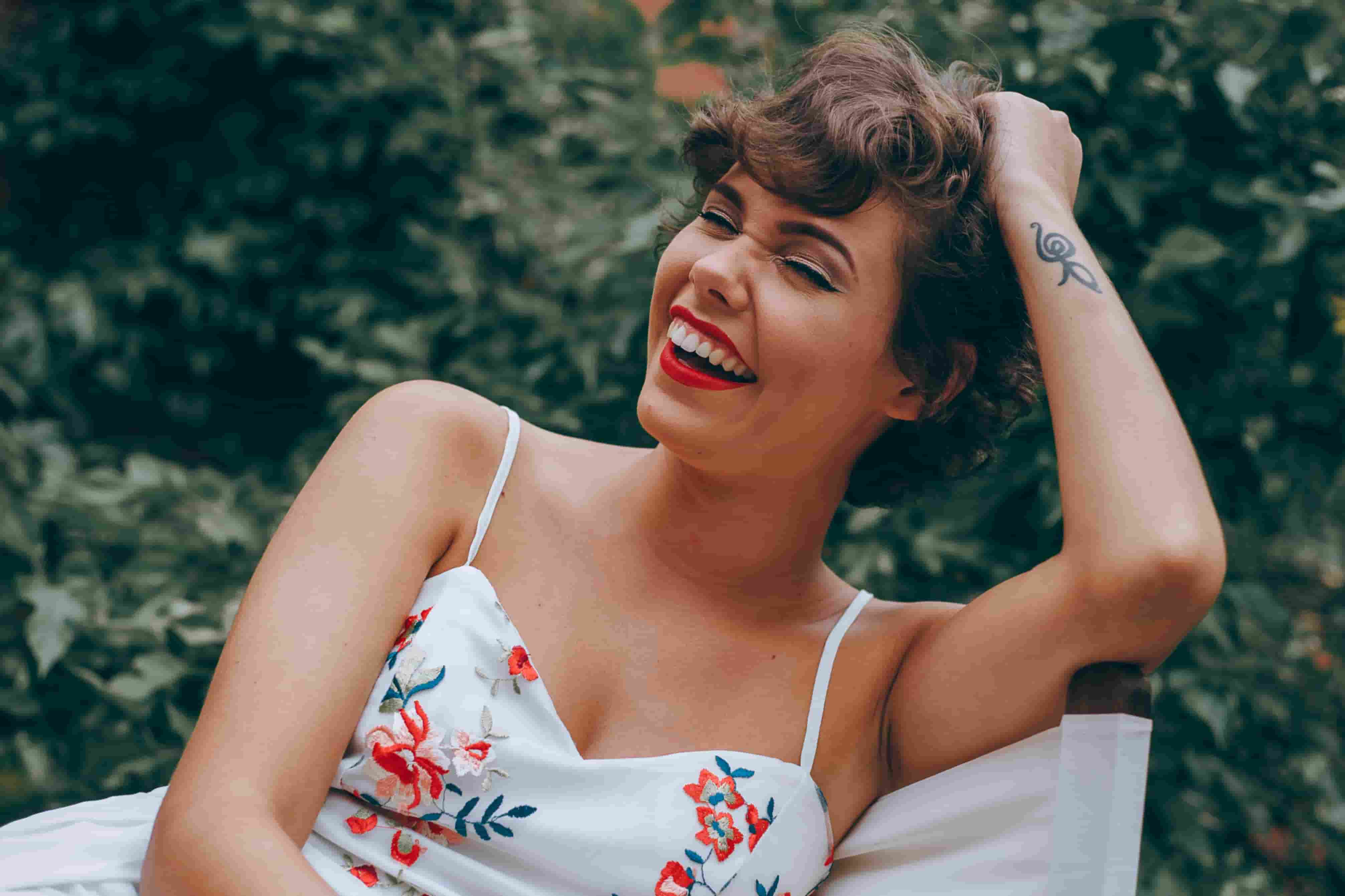  A photo of a short-haired Latina in a floral dress, smiling