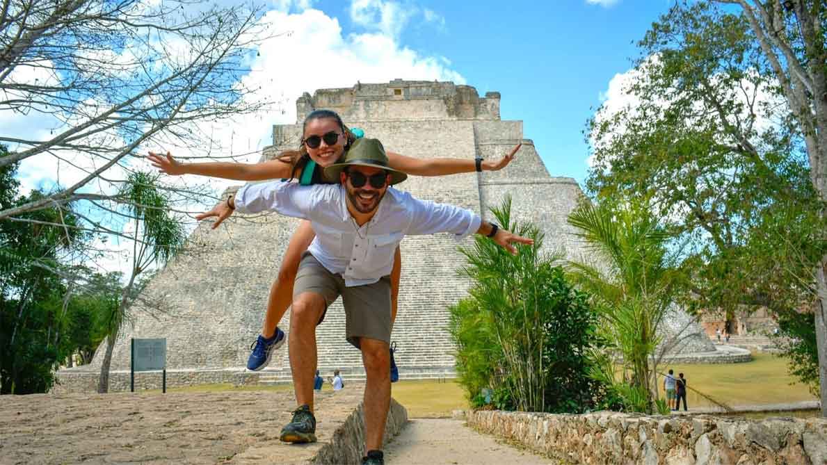 A couple posing in front of the Mayan Ruins.