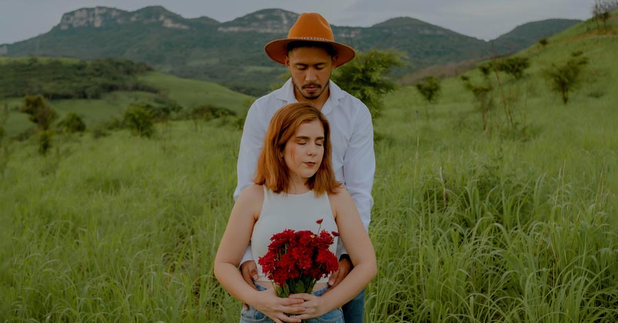 woman holding flowers with man behind her